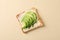 Toast with butter, avocado, arugula and sesame on beige background