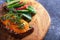 Toast with cottage cheese and yellow tomato, pumpkin seeds, greens on wooden Board on grey background, healthy vegetarian snack