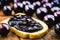 Toast with grape jam, on rustic wooden table. Jabuticaba, exotic Brazilian fruit, used in cooking, as a sweet