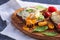 Toast with poached egg, cottage cheese, avocado and vegetables on wooden Board on white kitchen towel, healthy rural Breakfast