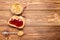 Toast sandwich with peanut butter. Spoon and jar of peanut butter, jam and peanuts for cooking breakfast on a brown wooden