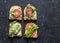 Toast sandwiches with avocado, salami, asparagus, tomatoes and soft cheese on dark background, top view. Tasty breakfast, snack or