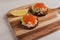 Toast skagen - classic Swedish appetizer. Sandwich with shrimps and caviar served on wooden board. Healthy breakfast.