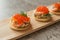 Toast skagen - classic Swedish appetizer. Sandwiches with shrimps and caviar on dark table. Selective focus