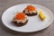 Toast skagen - classic Swedish appetizer. Sandwiches with shrimps and caviar on white plate. Nordic cuisine