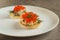 Toast skagen - classic Swedish appetizer. Sandwiches with shrimps and caviar on white plate. Selective focus