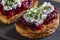 Toast from a slice of bread with white cream cheese, stewed beetroot pulp, seeds and green dill on wooden board. Delicious