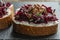 Toast from a slice of bread with white cream cheese, stewed beetroot pulp, seeds and green dill on wooden board. Delicious