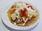 toast, typical Mexican tortilla fried with vegetables, cream, cheese and sauce