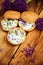 Toasted bread bruschetta with cream cheese and garlic edible flowers on olive wooden cutting board on stone slate gray background.