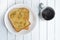 Toasted bread with garlic and marijuana leaves served with hot coffee on white wooden table background.