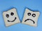 toasted bread with smiley and sad emoticons, for the concept of happiness and sadness