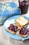 Toasted cereal bread slices on blue ceramic plate and homemade wild berries jam in jar, spoon and linen napkin