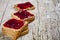 Toasted cereal bread slices with homemade cherry jam closeup on rustic wooden table background