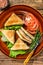 Toasted Club sandwiches with pork ham, cheese, tomatoes and lettuce on a plate. wooden background. Top view