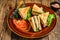 Toasted Club sandwiches with pork ham, cheese, tomatoes and lettuce on a plate. wooden background. Top view