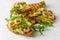 Toasts with avocado, shrimps and arugula on white background