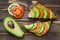 Toasts with avocado and tomato on a wooden table