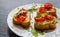 Toasts (Crostini) with ricotta, cherry tomatoes and arugula