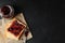 Toasts and glass jar with jam, spoon and baking paper on black background