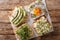 Toasts with hummus, avocado, feta cheese, microgreen and egg closeup. horizontal top view