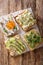 Toasts with hummus, avocado, feta cheese, microgreen and egg closeup. Vertical top view