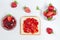 Toasts with strawberry jam for breakfast on white rusric wooden background. Top view