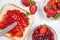 Toasts with strawberry jam for breakfast on white rusric wooden background. Top view