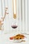 Tobacco chicken on a beautiful background with a glass of red wine, a vase with cotton twigs and a stylish lamp.