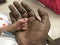 Today born infant hand palm inside the Adult men palms of an black man hands at hospital once baby boy was born and received by