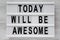 `Today will be awesome` words on modern board over white wooden background, top view. Overhead, flat lay, from above