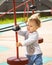 Toddler 1 year old girl boy Caucasian, playing on playground, baby with wavy blonde hair in the wind