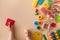 Toddler activity for motor and sensory development. Baby hands with colorful wooden toys on table top view