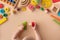 Toddler activity for motor and sensory development. Baby hands with various colorful wooden toys on table top view