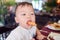 Toddler baby boy child biting & eating sausages