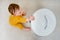 Toddler baby boy opens a trash can with household waste. Children`s safety issues in the home room, little kid