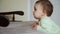 Toddler baby standing near sofa and watching cartoons calm and concentrated at home, calm time