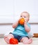 Toddler biting an orange