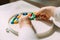 A toddler with both hands lays out a colored mosaic in a plastic mold