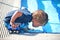 Toddler boy blowing bubbles in a pool