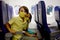 Toddler boy, child boarding on the airplane, sitting and waiting for departure, playing with toys