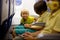 Toddler boy, child boarding on the airplane, sitting and waiting for departure, playing with toys