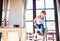 Toddler boy in a dangerous at home, climbing into highchair.