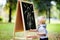 Toddler boy drawing standing by a blackboard