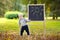Toddler boy drawing standing by a blackboard