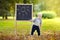 Toddler boy drawing standing by a blackboard