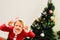 Toddler boy with funny face wearing Santa costume trying to scare like the grinch, expressions and christmas concepts on 