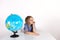 Toddler boy with a globe on the lesson of practical life on a white background, Montessori class, isolate.