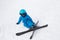 Toddler boy in helmet, glasses, skis and blue overalls at ski resort. Children`s skiing lesson
