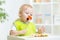Toddler boy in a highchair for feeding with a fork